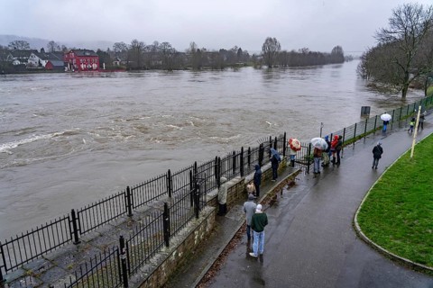 Spectators at high water on the Ruhr, here near Essen-Kettwig, below the weir of the Ruhr reservoir