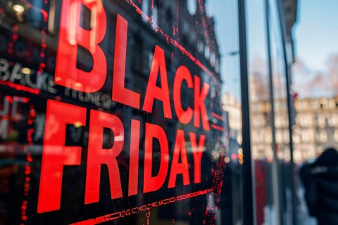 Black advertisement sign with red text 'Black Friday' in shopping window. Generative AI, AI
