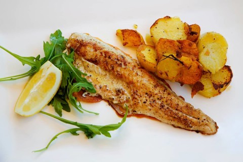 Mediterranean cuisine, fried pike-perch fillet, roast potatoes, fried potatoes, rocket salad, lemon