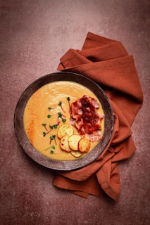 Pumpkin cream soup, curry, fried bacon, bruschetta chips, micro-greens, top view, no people