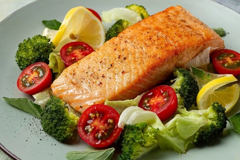 Grilled salmon fillet, with vegetables, broccoli, cherry, iceberg lettuce, spices and herbs,