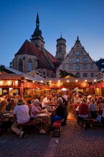 People sitting in vine arbours in the evening, wine village Stuttgart, Schillerplatz, collegiate
