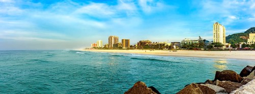 Panoramic photograph of Barra da Tijuca beach seen from the breakwater pier at dawn in the city of