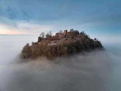 Aerial view of the Hegau volcano Hohentwiel with the upper fortress ruins in front of sunrise,