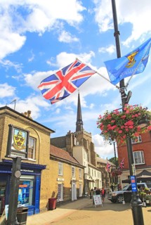 Flags frame view of spire St Peter and St Mary church in town centre, Stowmarket, Suffolk, England,