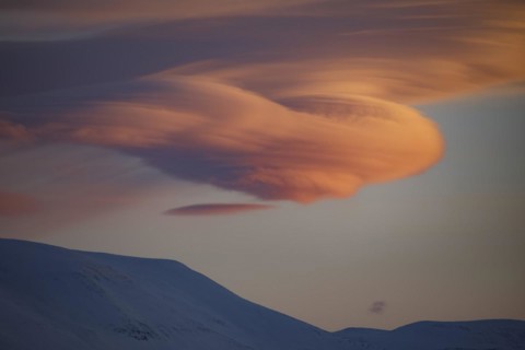 Lenticularis clouds at sunrise over mountains in winter
