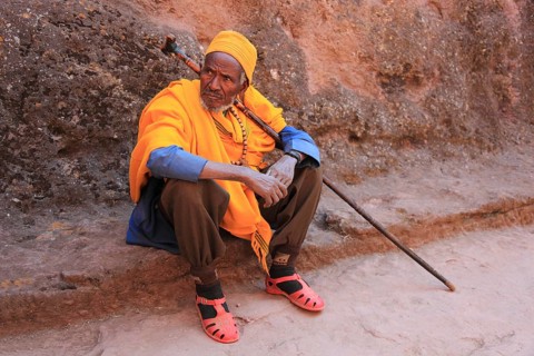 Rock churches of Lalibela, pilgrim sitting in front of a rock church, Ethiopia, Africa