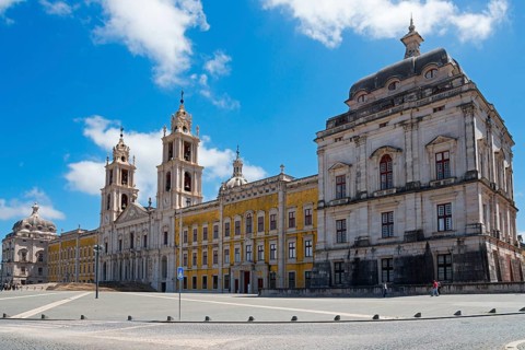 Spacious square in front of a magnificent baroque palace with towers under a blue sky, National