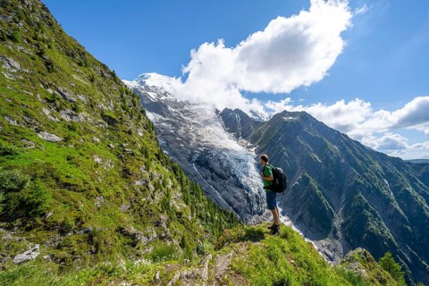 Mountaineer in front of impressive mountain landscape with glacier, view of glacier Glacier de