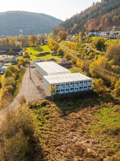 Warehouses surrounded by autumnal forest and village houses, refugee accommodation Beermiß,