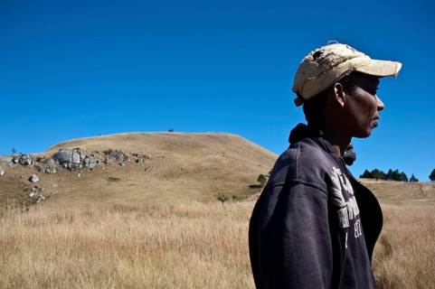 Portrait of a young man belonging to the Betsileo ethnic group. In the background, a sacred hill is
