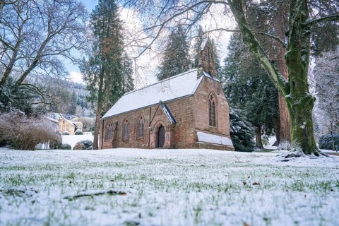 A snow-covered church embedded in a wintry landscape, spa garden, English Church, Bad Wildbad,