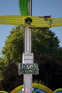 An employee works at the Chaos Pendulum ride at a dizzying height, Cranger Kirmes, Herne, Ruhr