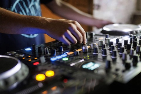 A DJ plays on a mixer and two Cdjs in Berlin, 14/08/2024