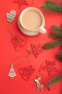 Christmas or New Year composition. Decorations, fir and spruce branches, cup of coffee, on a red