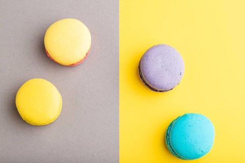 Yellow, purple and blue macaroons on trendy gray and yellow background. top view, copy space, close