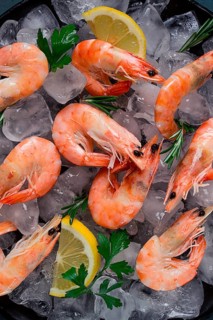 King shrimps, undivided, boiled-frozen, on ice, top view, selective focus, no people