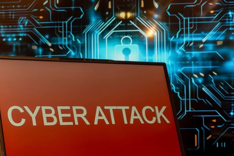 Cyber attack symbol: Laptop in front of a virtual computer background
