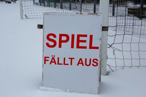 Symbolic image of a football match cancelled due to snow. Sign on a sports field with the