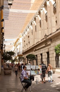 Fabric spread over buildings to provide shade in busy shopping street called Velazquez in central