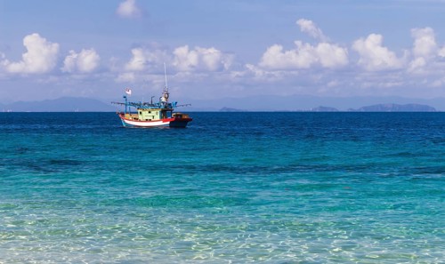 Blue sea and a small fishing boat. Malaysia