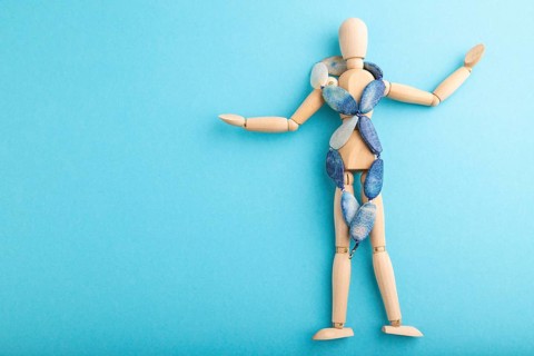 Wooden mannequin with blue agate beads on blue pastel background. copy space, isolated, luxury, bad