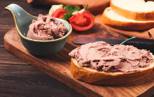 Liver meat pate spread, on white bread, on a wooden background, breakfast, close-up, no people,