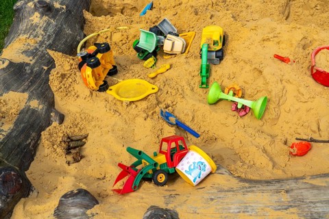 Sandpit, on a children's playground, sandpit with various plastic toys, excavator, shovels, moulds