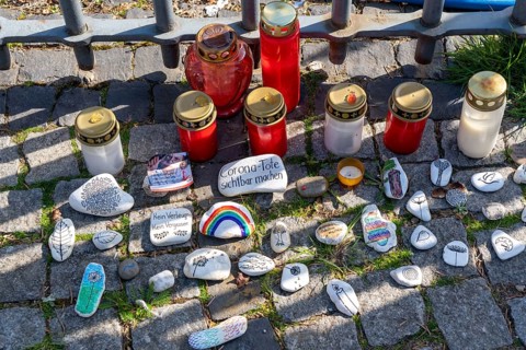 Candles and stones with inscriptions in memory of the dead of the corona pandemic, stickers from