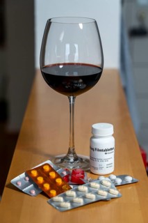 Symbolic image of alcohol and medication, you should not take medicine, pills, tablets with