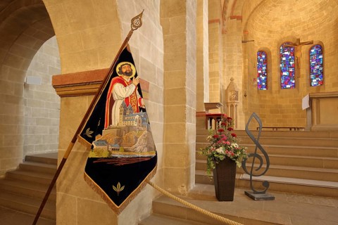 Interior view of the Romanesque basilica of St. Lubentius, chancel with flag of St. Lubentius,