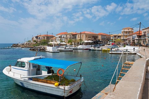 Quiet harbour with boats and surrounding buildings under a blue sky, Agios Nikolaos, Mani,