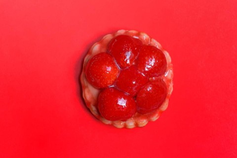 Strawberry tartlets on a red background, fruit cake