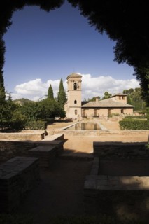 Ornamental garden with mirror water basin and a tower on the Alhambra palace grounds, Granada,