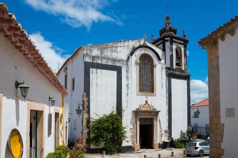 Baroque church with magnificent bell tower and blue sky, Church Igreja de São Pedro, Óbidos,
