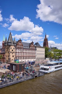 Saalhof with rent tower and excursion boats at the Mainkai under a blue sky with cumulus clouds in