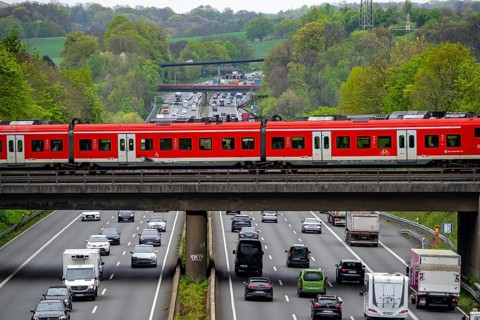S-Bahn train crossing the motorway A3, traffic on 8 lanes, incl. the temporarily released hard