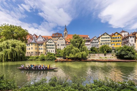 Neckarfront Tübingen with punt on the Neckar. Postcard motif with historic buildings, collegiate