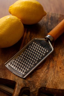 Lemons with a zest grater, on a chopping board, close-up, no people