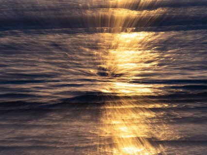 Abstract image of the North Sea, an early evening mood with colorful yellow reflections of the sun,