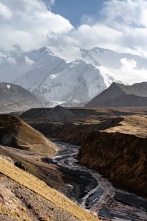 Achik Tash river, Achik Tash valley, behind glaciated and snow-covered mountain peak Pik Lenin,