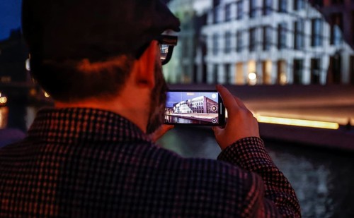 A man takes a photo of the Humboldt Forum with a smartphone during the Festival of Lights, Berlin,
