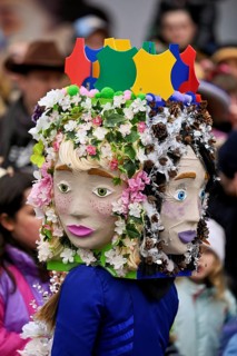 Person masked as a flower girl at the carnival parade of the Wey guild on Rose Monday, Güdismäntig,
