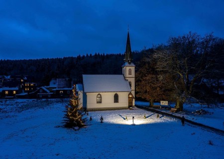 A Christmas tree stands in front of the smallest wooden church in Germany, Elend, 29 December 2020