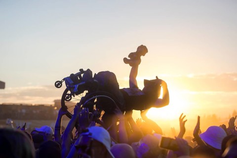 A wheelchair user crowdsurfing in front of sunset at the Highfield Festival on Friday, Störmthaler