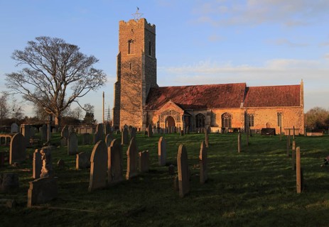 Late afternoon winter golden light falls on Saint John the Baptist church, Snape, Suffolk, England,