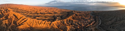 Panorama, landscape of eroded hills at Lake Issyk Kul, badlands at sunrise, aerial view, Canyon of