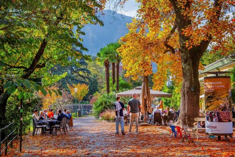 Winter promenade on the River Passer with street café in autumn, Merano, Burggrafenamt, Adige