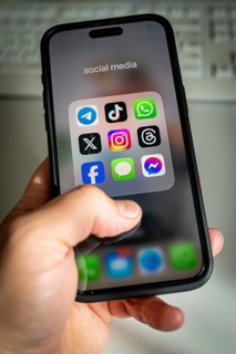 A smartphone shows various social media apps, threads, tik tok, Telegram & co on the screen
