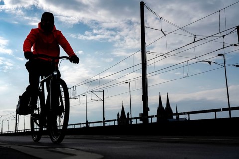 Cycling in the city, cyclist on the Deutzer Bridge in Cologne, Cologne Cathedral, cycle path, North